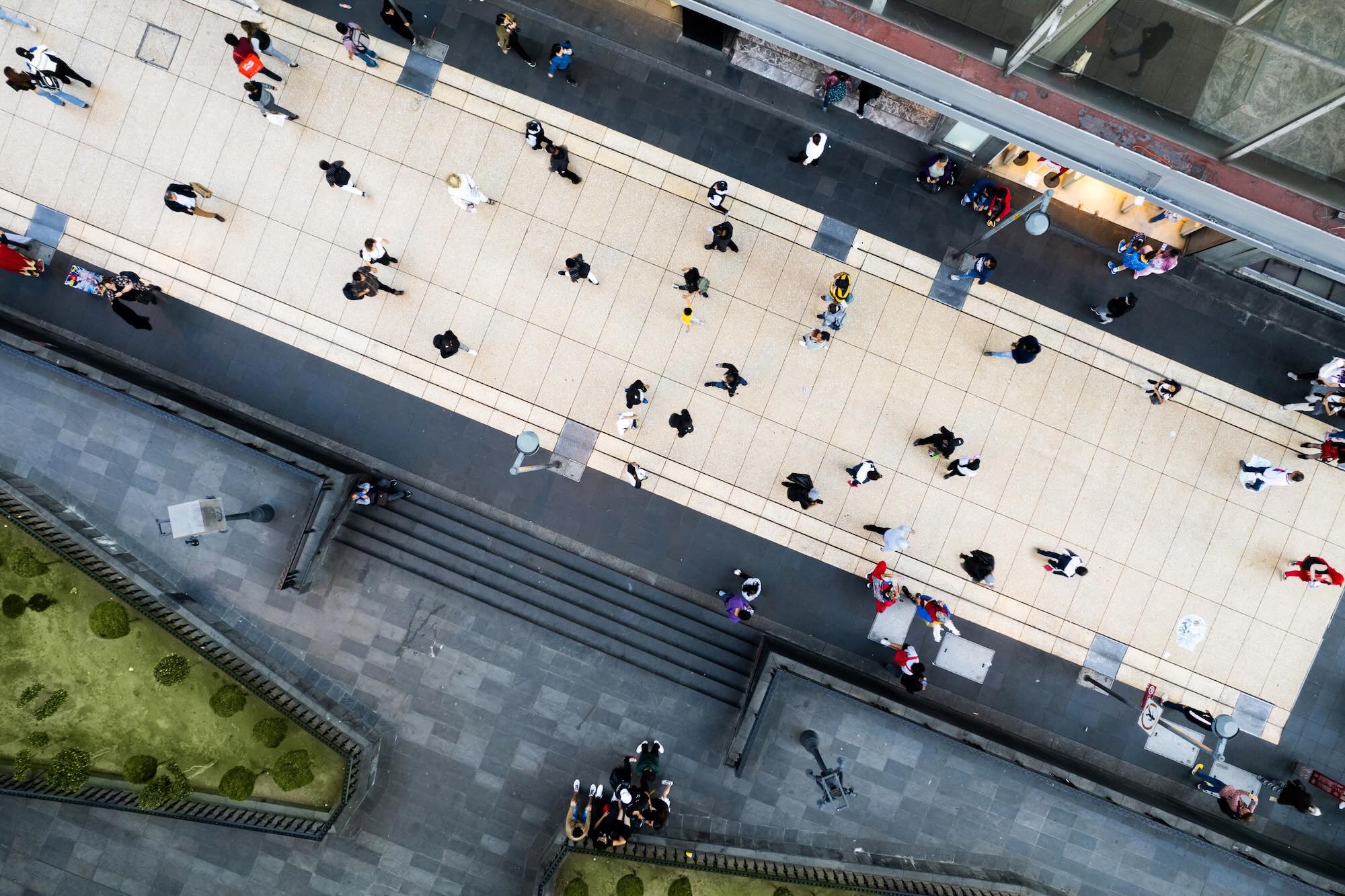 Overhead view of people walking on a sidewalk